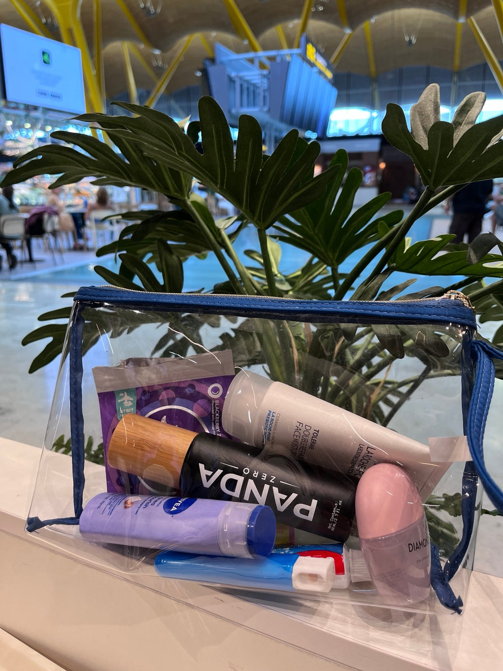 Panda Zero black body spray with bamboo cap packed in clear travel toiletry bag at airport