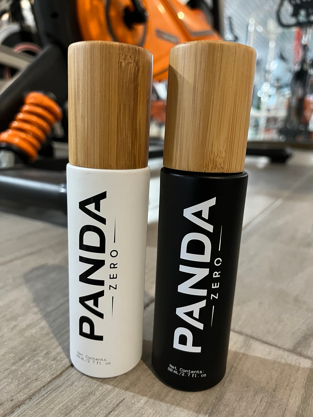 Panda Zero white and black bamboo cap body spray bottles side by side at gym