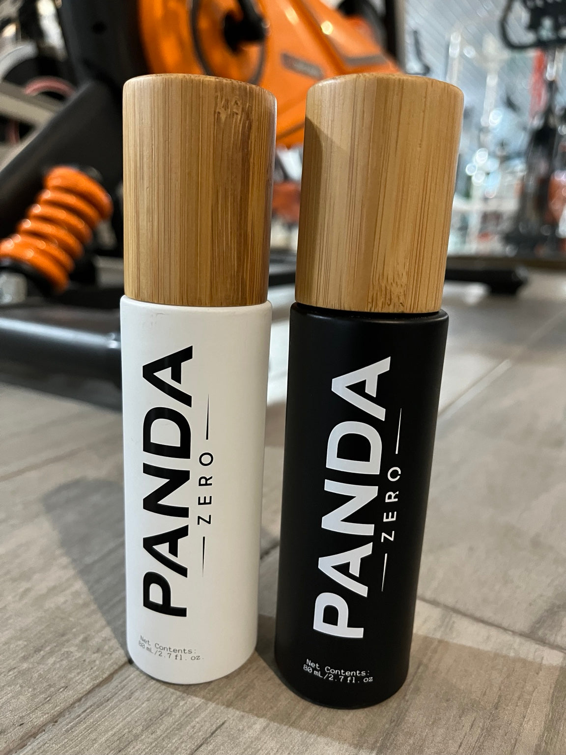 Panda Zero white and black bamboo cap body spray bottles side by side at gym