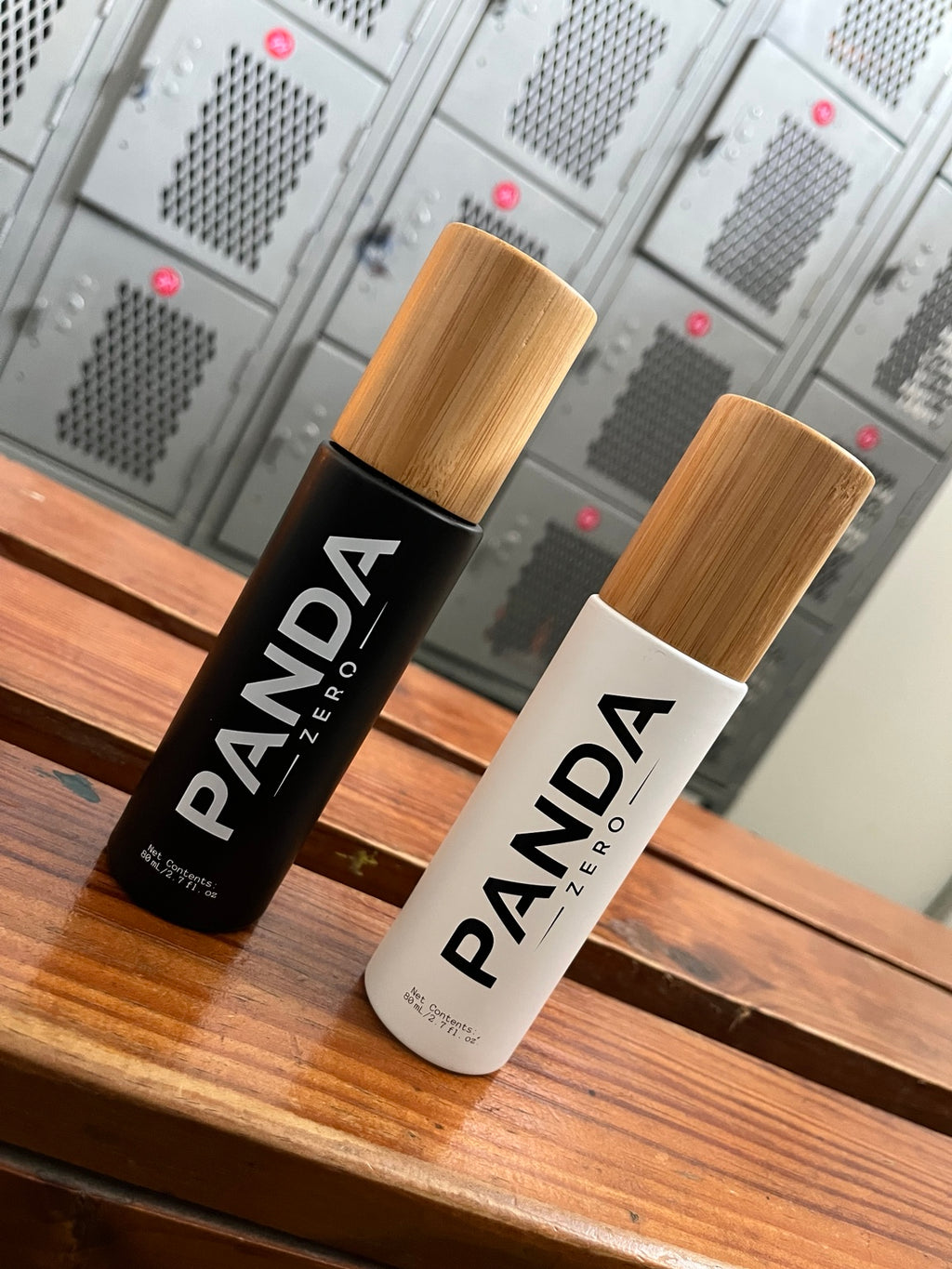 Panda Zero black and white bamboo cap body spray bottles on wooden bench in gym locker room